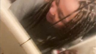 Blasian bent over bathroom sink while roommates in other room