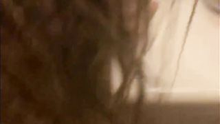 Blasian bent over bathroom sink while roommates in other room